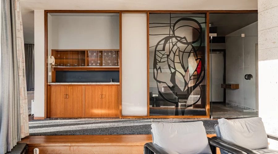 Een woonkamer met stoelen en een glazen deur.