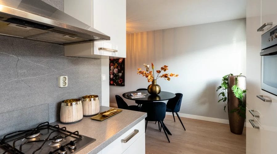 Een keuken met een fornuis en een eettafel. meubels huren, meubelverhuur luxe pakket