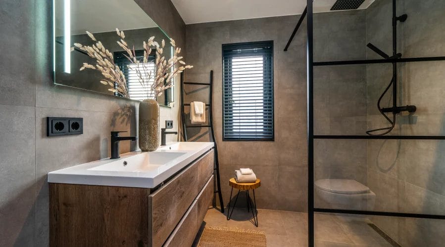 Een moderne badkamer voorzien van een douche en wastafel. meubels huren, meubelverhuur luxe pakket