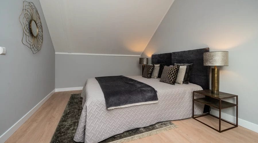 Een slaapkamer met een bed en een nachtkastje. meubels huren, meubelverhuur luxe pakket