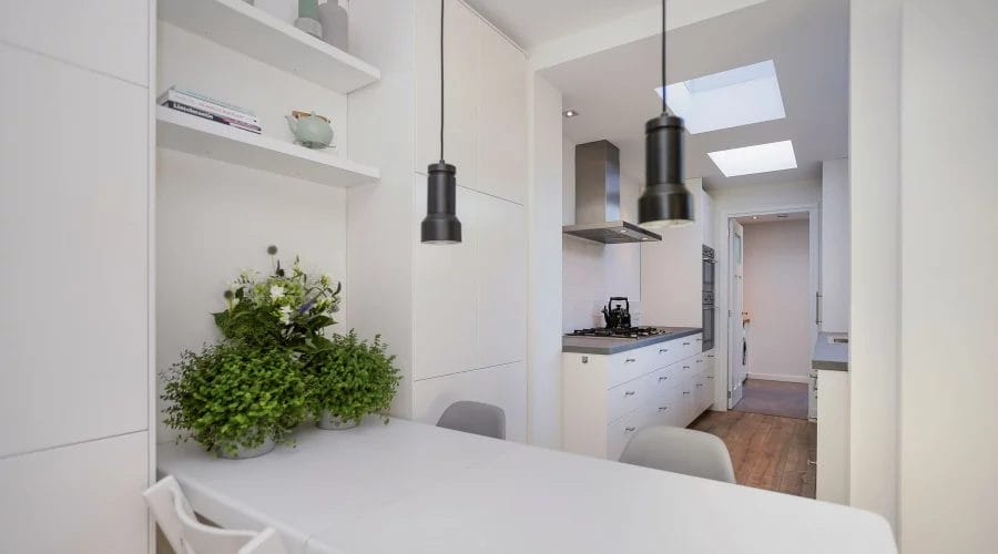 Een witte keuken met een tafel en stoelen. verkoopstyling schiedam, neutrale inrichting, woningfotografie