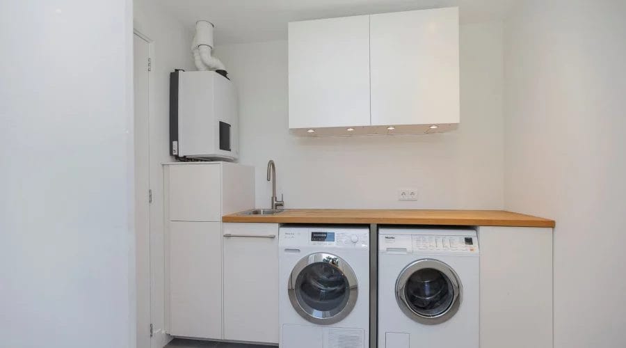 Een wasruimte met een wasmachine en droger. verkoopstyling schiedam, neutrale inrichting, woningfotografie